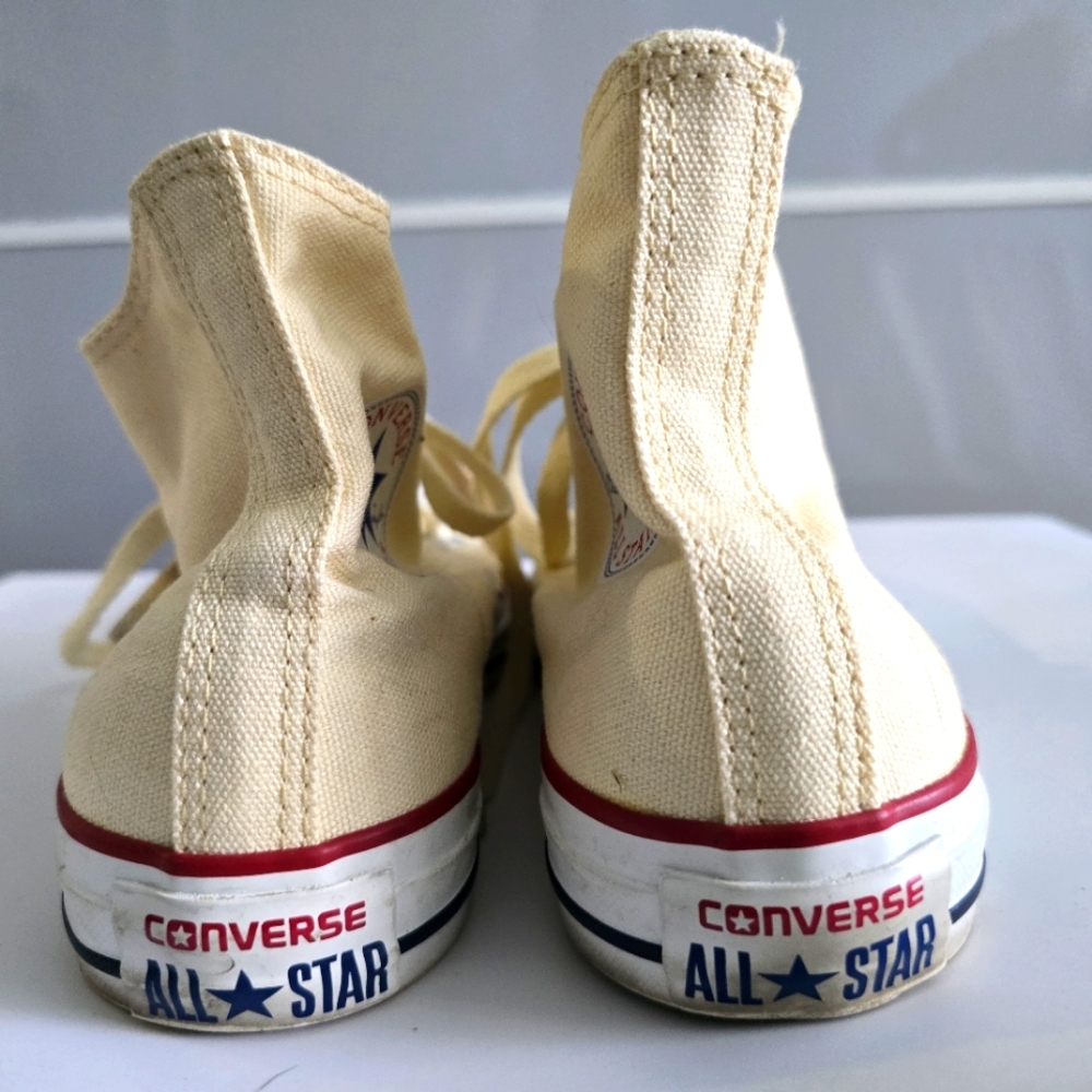 Cream Converse high tops.